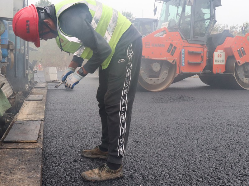 5、油層施工員任慶波隨時測量瀝青層松鋪厚度_副本